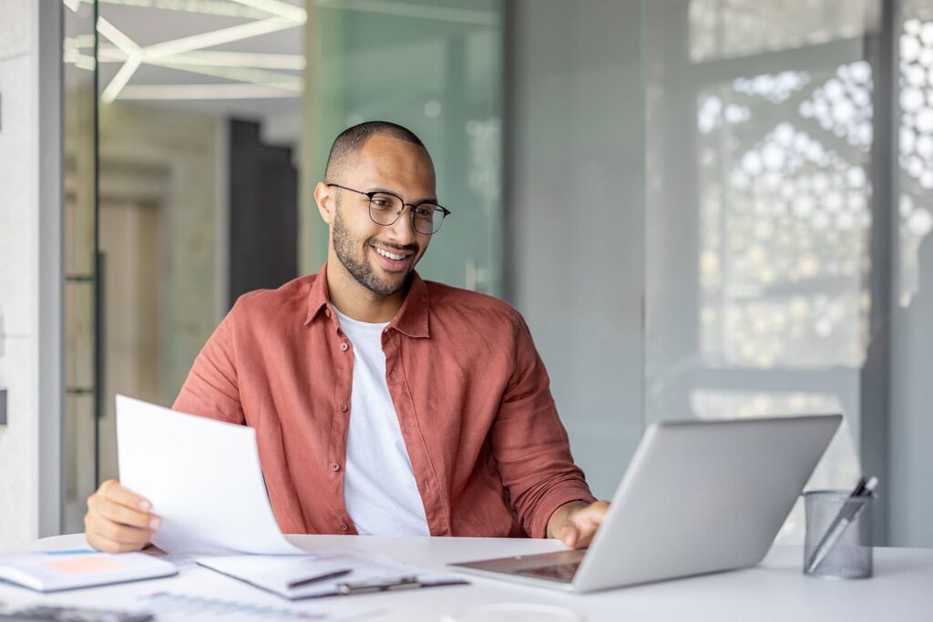 Man with laptop and paperwork